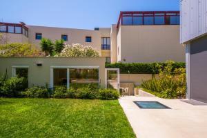 een huis met een gazon voor een gebouw bij Chalet Lídia Lodges in Estoril