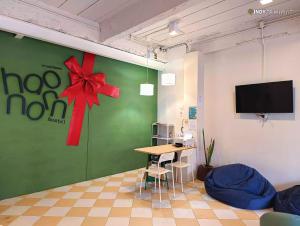 a room with a green wall with a red bow on it at haonornhostel in Ban Madua Wan