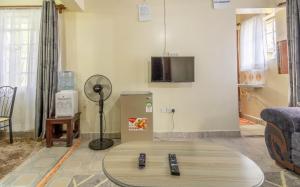 a living room with two remote controls on a table at Bremu Home - Near jkia airport in Nairobi