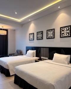 a hotel room with two beds with white sheets at Bangi Resort Hotel in Bangi