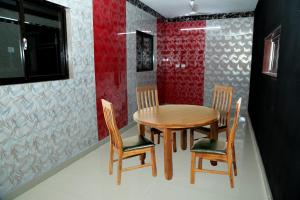 a wooden table and chairs in a room at MM Residency Mogappair in Chennai