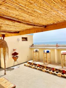 a patio with chairs and a table with a view at Waveside surf house in Tamraght Ou Fella