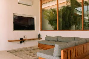 a living room with a couch and a tv at Villa Lucilla, beautiful Villa in the heart of Uluwatu in Uluwatu
