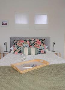 a tray with wine glasses and a plate on a bed at Boat Haven Studios in Goolwa