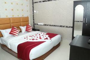 a bedroom with a bed with red and white pillows at MM Residency Mogappair in Chennai +1 photo