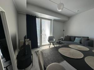 a living room with a couch and a table at Pramea Apartments Asematalo in Kuopio