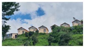 a row of houses on top of a hill at Hotel Himaaksh cottages In Sigri in Nainital