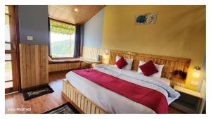 a bedroom with a large bed with red pillows at Hotel Himaaksh cottages In Sigri in Nainital