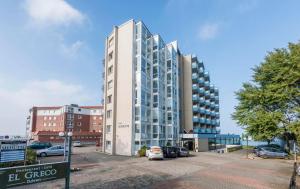 a tall white building with cars parked in a parking lot at Seehütte - 304 in Cuxhaven