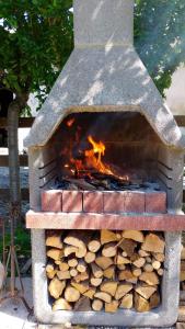 a stone pizza oven with a pile of wood at Il Vecchio Casale in Luco dei Marsi