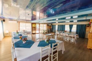 a large room with tables and chairs with flowers on them at Tiena Hotel Plutitor in Turcoaia