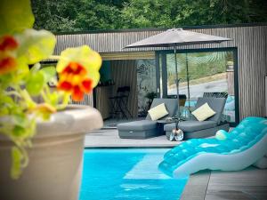 ein Swimmingpool mit einer Couch und einem Sonnenschirm neben einem Swimmingpool in der Unterkunft Pool House 85 in Spa