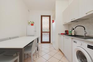 una cucina con lavello e lavatrice di Casa di Shrek 110mq grande terrazzo- 6 POSTI LETTO -MODERNO TRILOCALE a Cesate