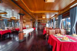 Un vagón comedor de un tren con mesas y sillas rojas. en Sunlight Legend 12 Ha Long Bay, en Ha Long