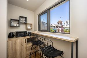 a bar with two chairs in front of a window at Bliss Luxury Apartments in Athens