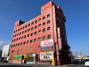中津市にあるNakatsu Sunrise Hotel - Vacation STAY 64664vの目の前に看板が出た高い赤い建物