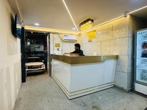 Una mujer parada en un mostrador en un restaurante en Hotel 7 Star Rohini Sector 17, en Nueva Delhi