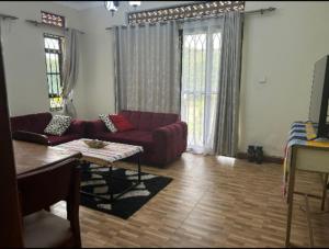 a living room with a couch and a table at Katabi Green Escape in Entebbe