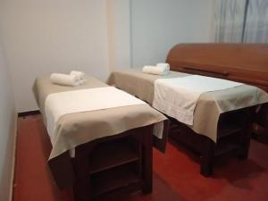 two twin beds in a room with a piano at Siddhajeewa Ceylon Herbs in Ella