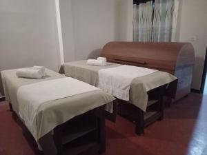 a room with two beds with white sheets at Siddhajeewa Ceylon Herbs in Ella