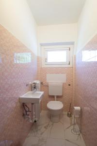 a bathroom with a toilet and a sink and a window at Fernblick in Sluderno +11 photos