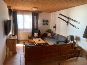 a living room with a couch and a table at Cozy Alpe in Treffen
