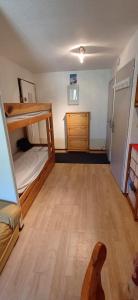 a bedroom with a bunk bed and a wooden floor at Appartement 4 personnes proximité centre et remontés mécaniques in Châtel