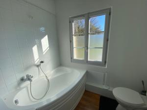 a white bathroom with a tub and a toilet at Grande maison de caractère 14 pers Gîte centre de la France in Saint-Maur +26 photos