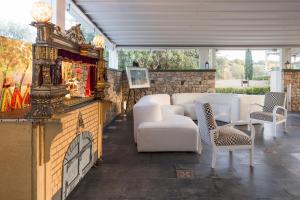 Una sala de estar con muebles blancos y chimenea. en Villa Luna, en Scicli