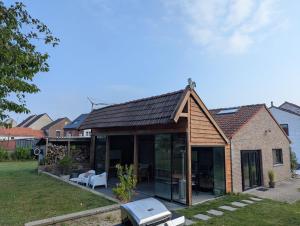an extension to a house with glass doors at Vacation on the farm in Lanaken