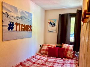 een slaapkamer met een bed met een geruite deken bij RPP C213 - Charmant appt 4pers-Ski aux pieds in Tignes