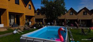 a pool with a plastic swan in it in a yard at Domki NA PNIU in Jarosławiec