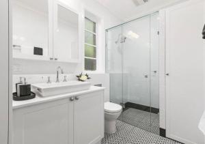 a white bathroom with a sink and a toilet at Stylish Apartment, Malvern East in Melbourne +14 photos