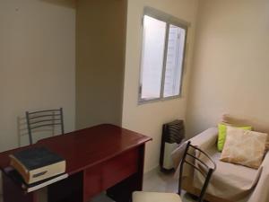 a office with a desk and a couch and a window at Apart POTRERILLO in San Fernando del Valle de Catamarca +2 photos