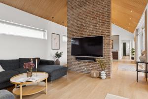 a living room with a couch and a brick wall at Feriehus 1116 in Ringkøbing