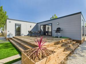 a backyard with a wooden deck and a house at Chalet avec piscine pour 4 adultes-2 enfants in Le Sablais
