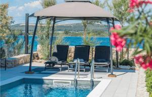 a group of chairs under a gazebo next to a pool at Villa Royal House 1 in Pašman