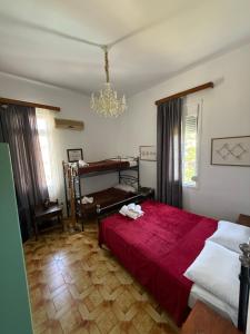 a bedroom with a red bed and a chandelier at Tower Traditional Pool Villa in Kremasti +24 photos