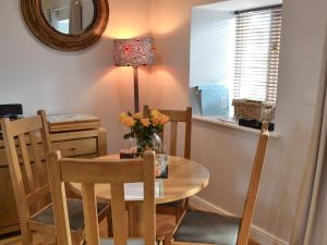 Un comedor con una mesa y sillas y un espejo. en Beach Comber Cottage, en Marazion