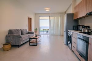 a kitchen and living room with a couch and a table at THEODOROU villas in Kos Town
