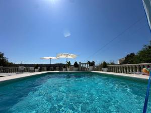basen z niebieską wodą i parasolem w obiekcie Villa Maja Calpe w mieście Calpe