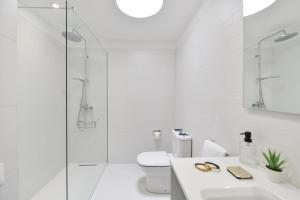 a white bathroom with a toilet and a glass shower at Campo Golf 68 by VillaGranCanaria in Las Palmas de Gran Canaria +16 photos