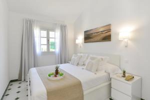 a white bedroom with a white bed and a window at Campo Golf 68 by VillaGranCanaria in Las Palmas de Gran Canaria