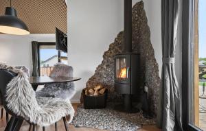 a fireplace in a living room with a table and a chair at 3 Bedroom Awesome Home In Tarm - P52739 in Tarm