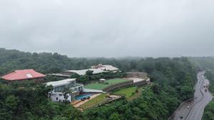 罗纳瓦拉Ikshana Resort and Spa, Khandala的享有山丘上建筑空中景观和道路