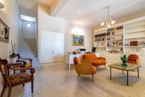 a living room with orange chairs and a table at Dimora Sella - Villa Alice in Alghero