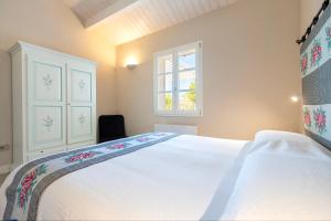 a bedroom with a large white bed and a window at Dimora Sella - Villa Alice in Alghero