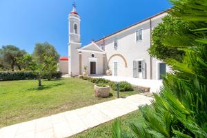 a church with a clock tower in a yard at Dimora Sella - Villa Alice in Alghero