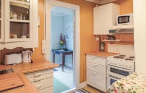 a small kitchen with white cabinets and a table at 4 Bedroom Cozy Home In Mandal - Nvk242 in Ime