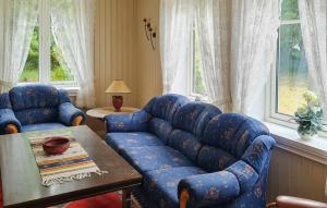 a living room with a blue couch and a table at 4 Bedroom Cozy Home In Mandal - Nvk242 in Ime +9 photos